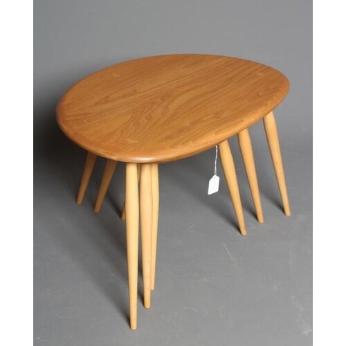 AN ERCOL BEECH AND ELM NEST OF THREE "PEBBLE" TABLES, the we...