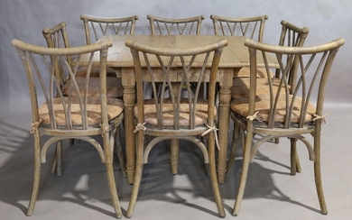 An OKA 'Charlotte' weathered oak drop leaf extending dining table, with four extra leaves, raised on ring turned supports, 76cm high, 290cm wide, 110cm deep, together with eight matching dining chairs by OKA, with wicker seats and leather cushions...