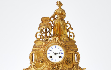 TABLE PENDULUM. Louis XV style, late 19th century/early 20th century, gilded metal decor, enamelled dial with Roman numerals, crowned by female figure and jewellery box.