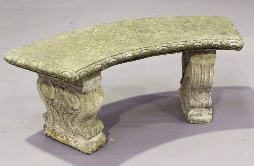 A 20th century cast composition stone garden bench, the curved seat on foliate scroll supports, heig