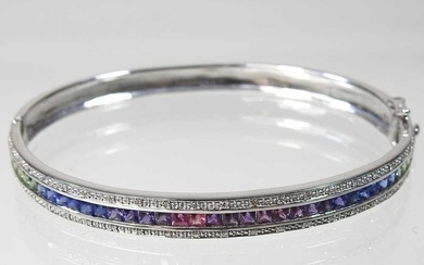 A 9 carat white gold and fancy sapphire bangle, of...