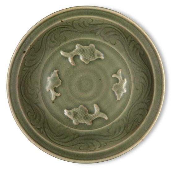 A Chinese Longquan celadon 'fish' dish, Ming dynasty, the interior decorated with four moulded fish surrounded by a band of incised waves, 32.4cm diameter, with wood stand