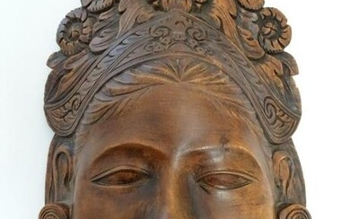 A Chinese carved wooden mask depicting a female face
