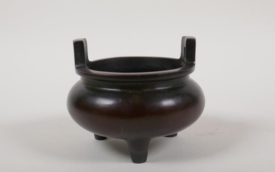 A Chinese two handled censer on tripod supports, impressed...