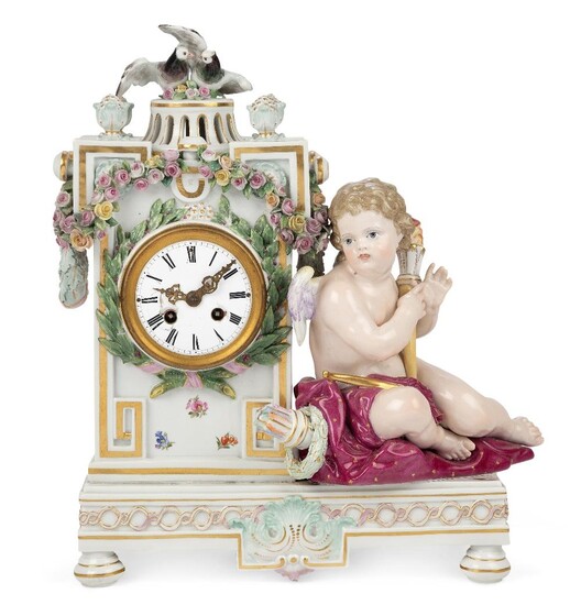 A Meissen porcelain mantel clock case, late 19th century, of architectural form, encrusted with a garland of flowers and oak leaf swags, with a pair of billing doves nesting atop a pierced neck surrounded by four flower finials, with a Cupid seated...