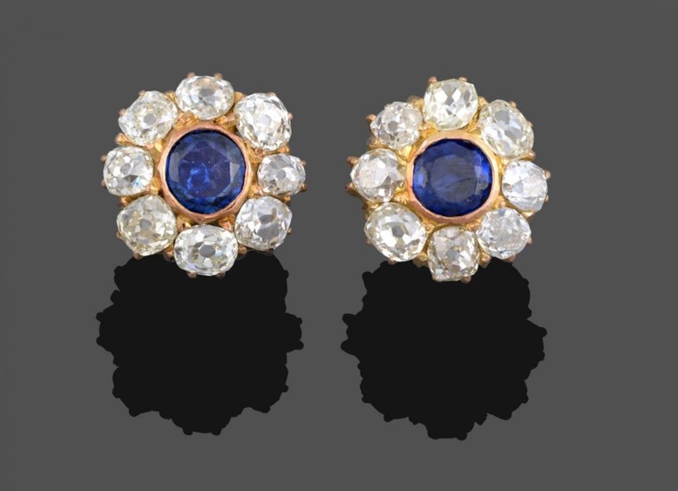 A Pair of Sapphire and Diamond Cluster Earrings, the round...