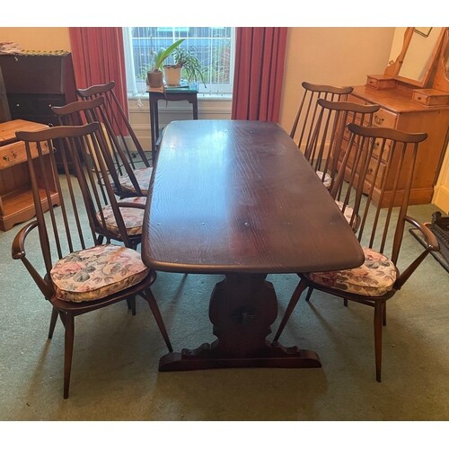 A VINTAGE LARGE ERCOL dining table with four chairs and two ...