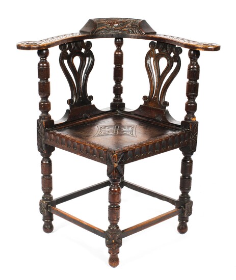 A Victorian carved oak corner chair, the foliate carved top rail with birds