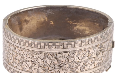 A Victorian sterling silver hinged bangle, engraved floral d...
