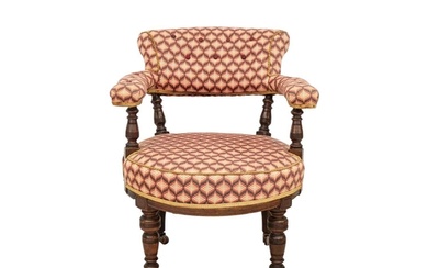 A Victorian walnut upholstered tub chair. With turned suppor...