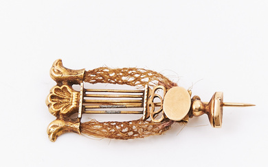 A brooch, 18k gold, in the shape of a lyre with hairwork, empire, crown with seashell decoration and 2 bird heads, first part of the 19th century, Swedish non-legible stamps.