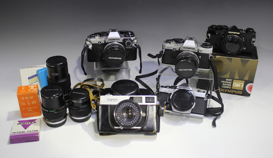 A collection of Olympus cameras and lenses, comprising OM-2 camera body, OM10 camera with Zuiko Auto
