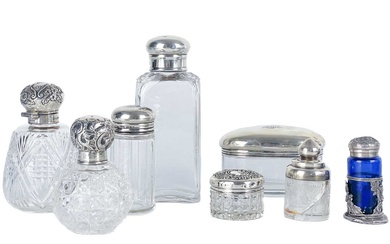 A collection of eight assorted silver-topped dressing table jars.