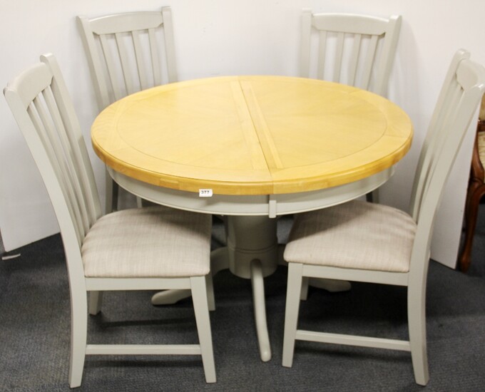 A contemporary extending circular dining table together with four painted finish dining chairs, Dia. 112cm.
