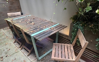 A garden table with four slatted folding chairs, the table w...