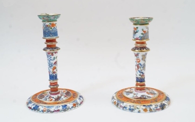 A near pair of Derby porcelain candlesticks, by Stevenson & Hancock, late 19th century, with chinoiserie decoration of flowers and butterflies, the undersides with iron red mark SDH, 19.5cm and 20.5cm high (2)