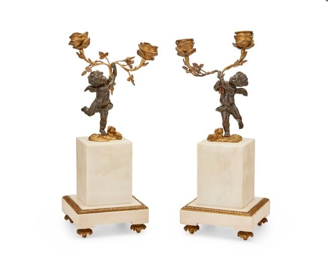 A pair of French patinated and gilt-bronze candelabra