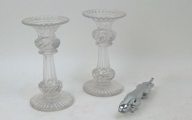 A pair of cut-glass candlesticks, 20th century, trumpet flaring rims with swirl form knops, 20cm high, together with a chrome plated Jaguar bonnet mascot, 20cm long (3)