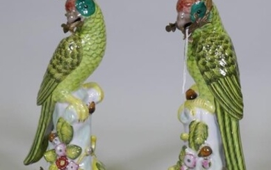A pair of porcelain parrot candlesticks with brass mounts,...