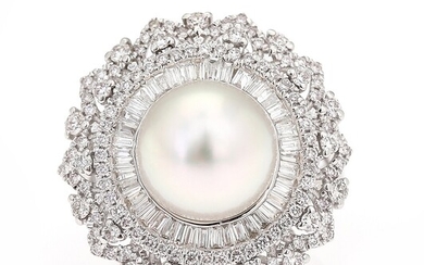 SOLD. A pearl and diamond ring set with a cultured pearl encircled by numerous diamonds...