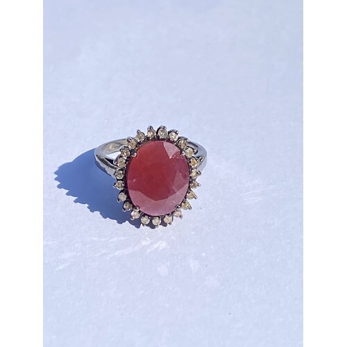 A ruby and diamond ring, of oval cluster design