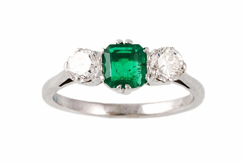 AN EMERALD AND DIAMOND THREE STONE RING, with one emerald of...