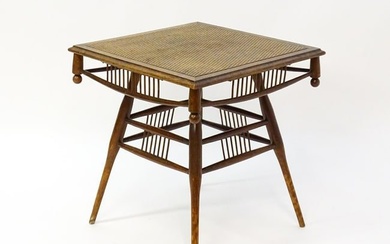 An unusual late 19thC Arts & Crafts table with a rattan inlaid moulded top above three tiers of