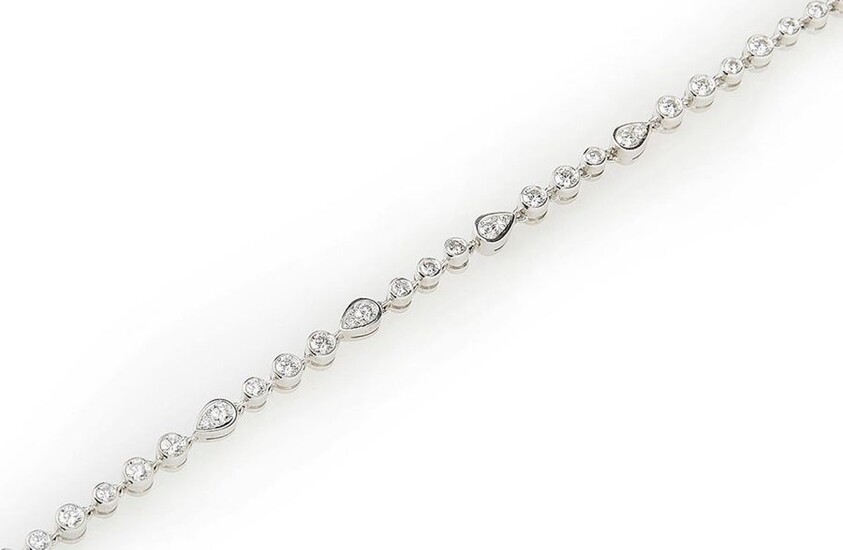 Bracelet ligne en or gris 18K (750/°°), composé de pastilles ornées de diamants ronds en serti clos, entrecoupées de diamants poire. Longueur : 16,5cm Poids brut : 8.2g