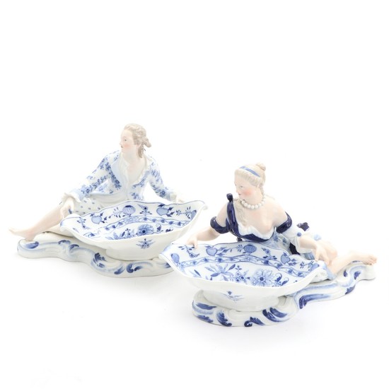 Two Meissen porcelain figural sweetmeat dishes, decorated in underglaze blue with “Zwiebelmuster”. H. 19. L. 31 cm. (2)