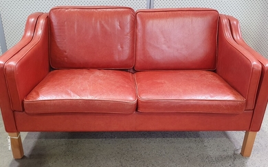 A BURNT ORANGE LEATHER UPHOLSTERED TWO SEAT SOFA