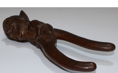 A Black Forest novelty lever-action nut cracker, carved as a...