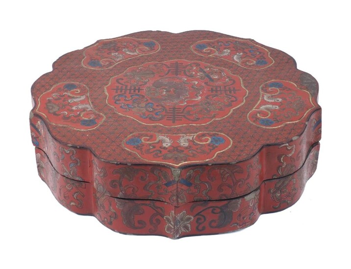 A Chinese red lacquer papier-mâché box, early 20th century, of shaped circular form, decorated with vignettes of fish, scrolling foliage and bats, 13cm high, 50cm diameter