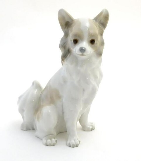 A Nao figurine modelled as a seated long haired