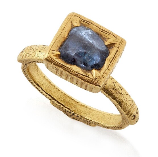 A South Indian sapphire ring, India, 18th century, the solid gold band engraved to shoulders with scale design and makara heads, the shank with a finely stippled design, the sapphire set in finely worked kundan technique with lobed edges and...