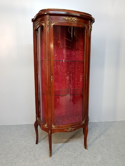 A Transitional style mahogany veneered glass cabinet with ormolu decoration,...