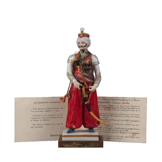 A Van Gerdinge / Sitzendorf porcelain figure of an 1813 Mameluk Capitaine, 20th century, no. 701, bearing factory marks to the underside, the figure with accompanying saber, twin pistols, short sword and satchel, on custom wood base with brass...