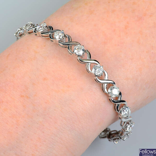 A brilliant-cut diamond line bracelet, with cross spacers.
