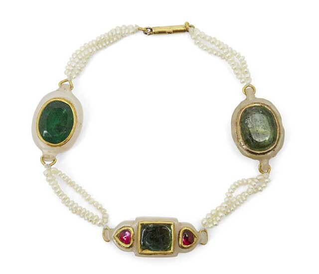 A gem-set jade and seed pearl bracelet, India, late 19th century, with three jade elements set with stones in gold surrounds, attached to each other with three strands of seed pearls, 20cm. long