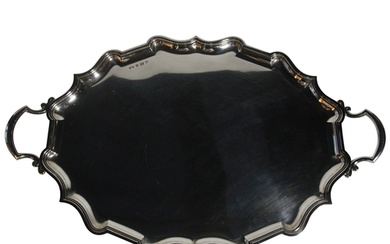 A massive silver two handled tray with shaped borders & hand...