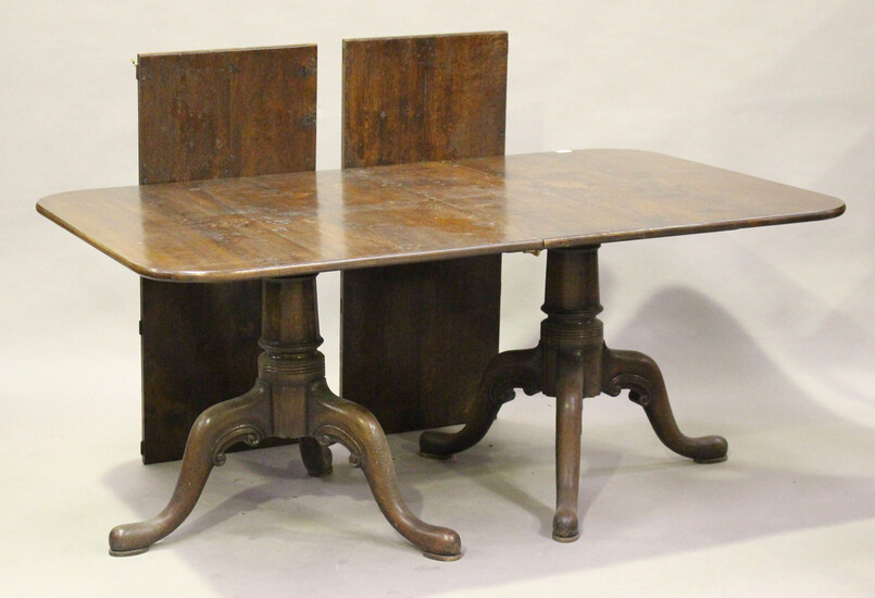 A modern 18th century style solid oak twin-pedestal dining table by Bylaw, the top with two extra le