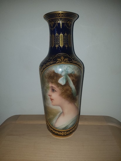 A porcelain vase with gilded decoration on blue ground, decorated in colours with women's portrait in cartouche. Vienna mark, but Germany, c. 1900. H. 32 cm.