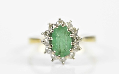 An 18ct yellow gold emerald and diamond oval cluster ring,...
