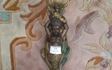 Applique en bronze ciselé, patiné et doré à décor d'un angelot en gaine retenant une...