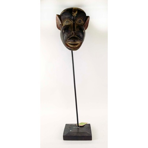 BAMOUR MASK, carved and painted wood on a metal stand with a...