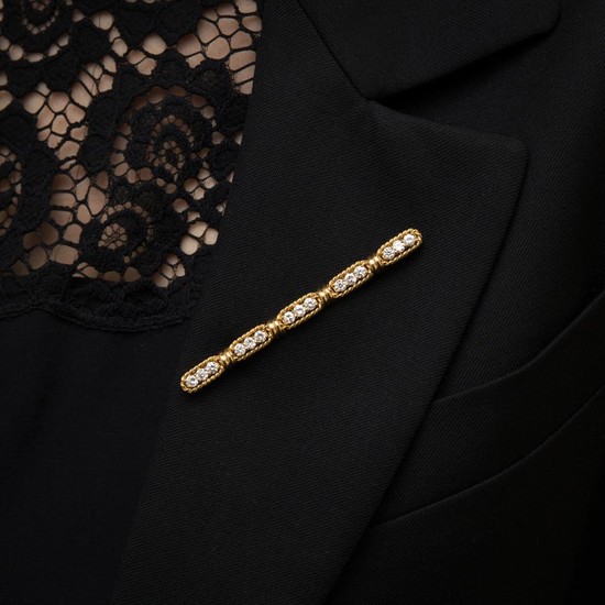BARRETTE DIAMANTS A diamond and gold bar-brooch.
