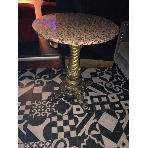 Circular restaurant table with decorative cast iron base gol...