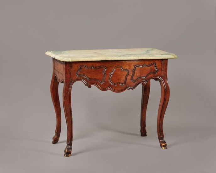 Console table in carved walnut with a slightly curved front underlined by reserves. It has a side drawer and rests on four curved legs ending in hooves. Provincial work from the end of the 18th century. Marble top. (Restorations and transformations)...