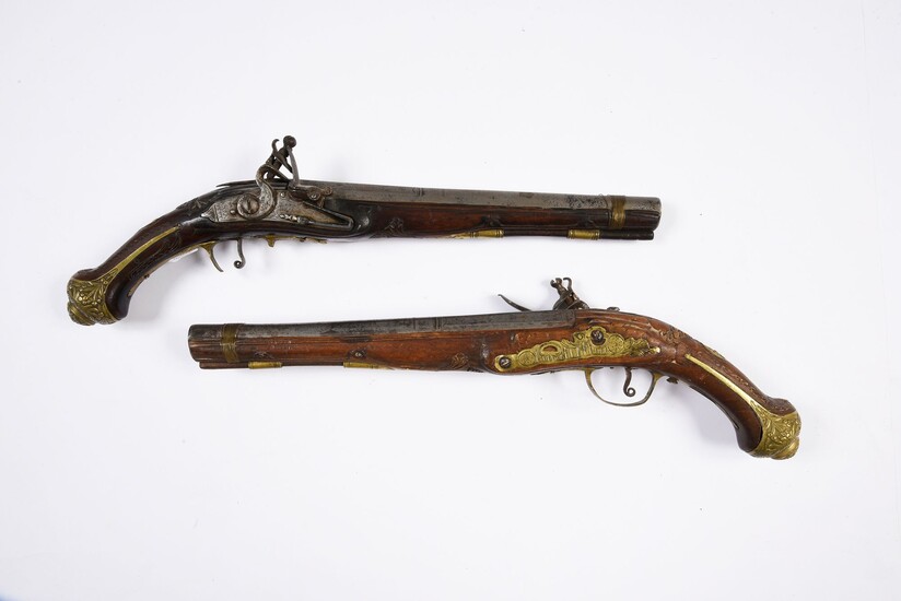 PAIR OF SILEX GUNS.Flat-bodied decks. Long shafts and moulded grips. Engraved bronze fittings with relief decorations. Thunder-punched barrels. One bridge is damaged and the action is defective. Early 19th century. Work for the Orient.L. 37 cm.