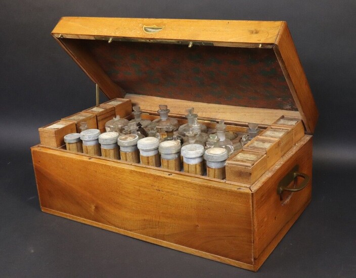 Field pharmacy by Cadet, the Emperor's pharmacist, Rue Saint-Honoré 108. Varnished walnut case opening on the top and front panel on three drawers. Upper part offering eight mobile wooden racks with lids on slides, eight pewter jars with lids and a...