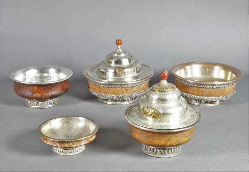 Set of five containers comprising: two covered wooden bowls with a silver metal frame. H. 10.5 and 11 cm; two wooden bowls with silver metal mounting and turquoise and coral inlays. D. 11.5 and 11.6 cm; one wooden bowl with silver-plated metal frame...